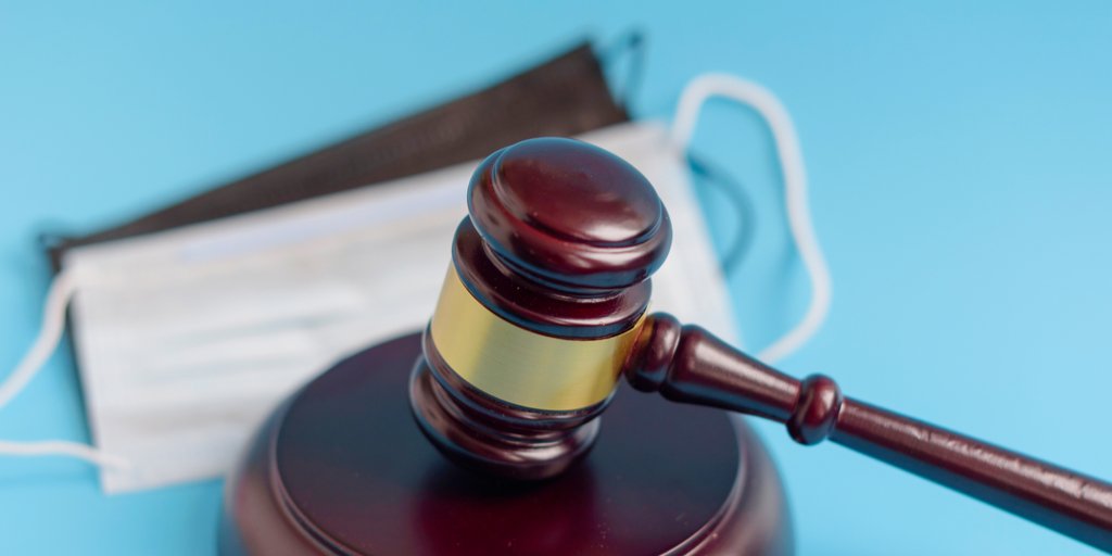 Judge's Gavel sitting on top of masks required under COVID-19 regulations